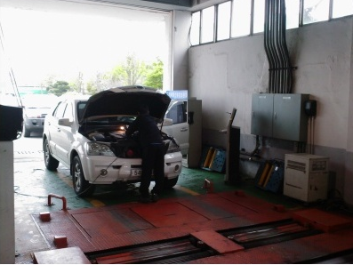 자동차를 검사하고 있는 모습의 사진입니다.